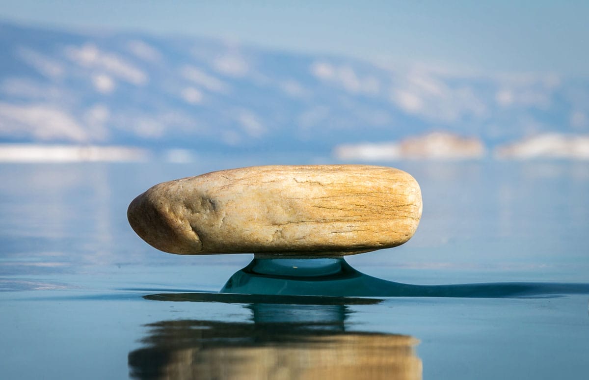 Les formations de glaces incroyables du lac Baïkal en hiver 1 Une petite pierre se dresse sur une "jambe" au-dessus de la glace du lac Baïkal.