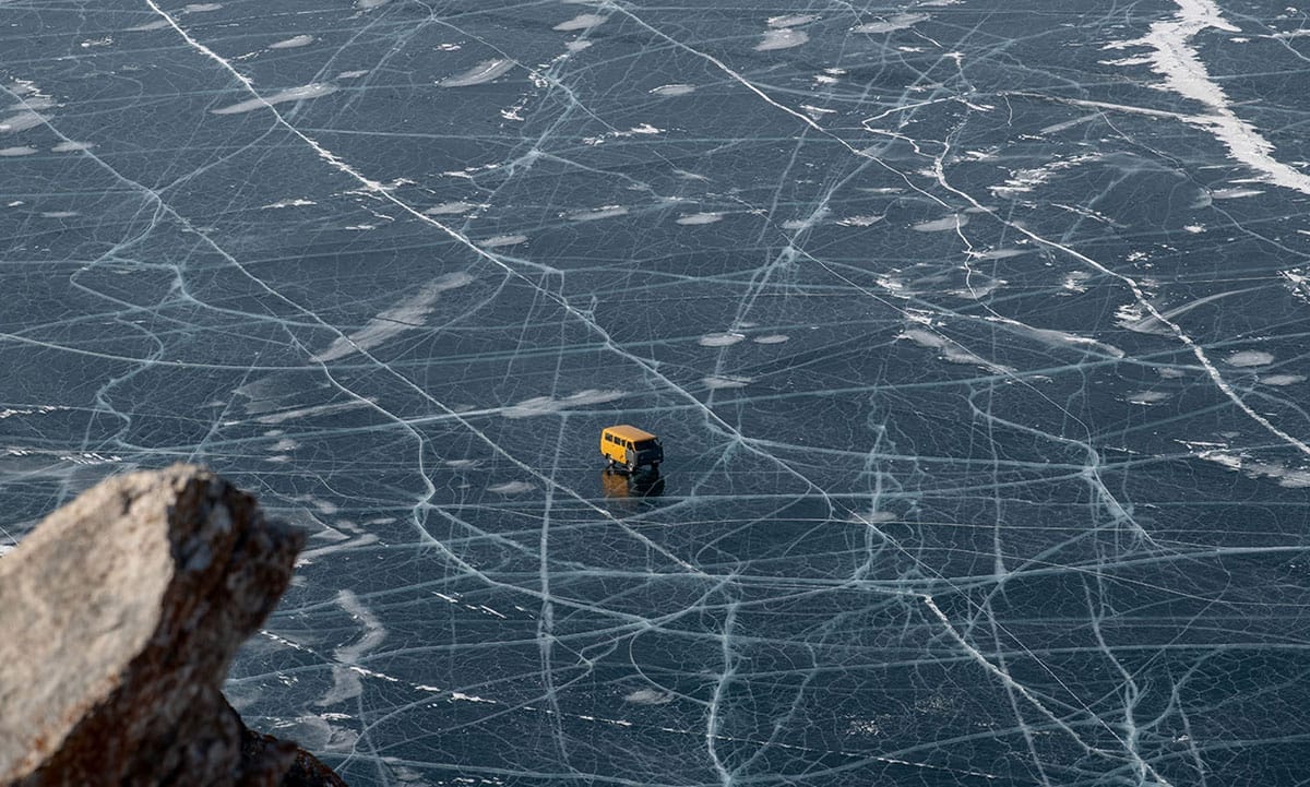  Une camionnette traverse la surface gelée de Baïkal, qui est entrecoupée de fissures