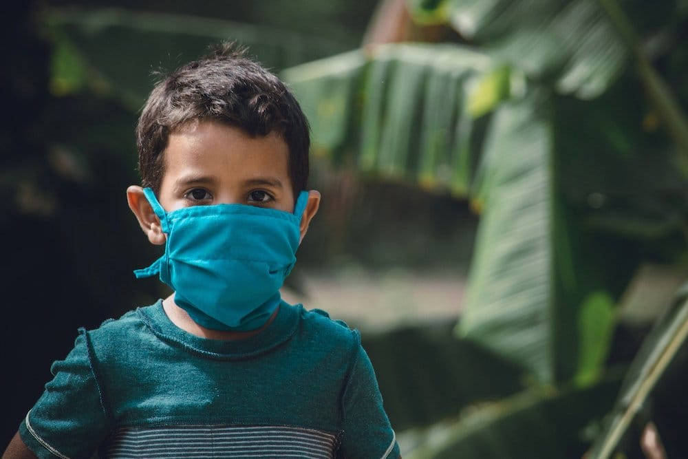 Un petit enfant portant un masque © DR