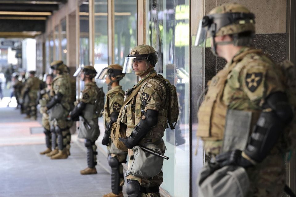 Des soldats non armés de la Garde nationale de Washington montent la garde devant un grand magasin, le lundi 1er juin 2020 à Seattle © Elaine Thompson/AP