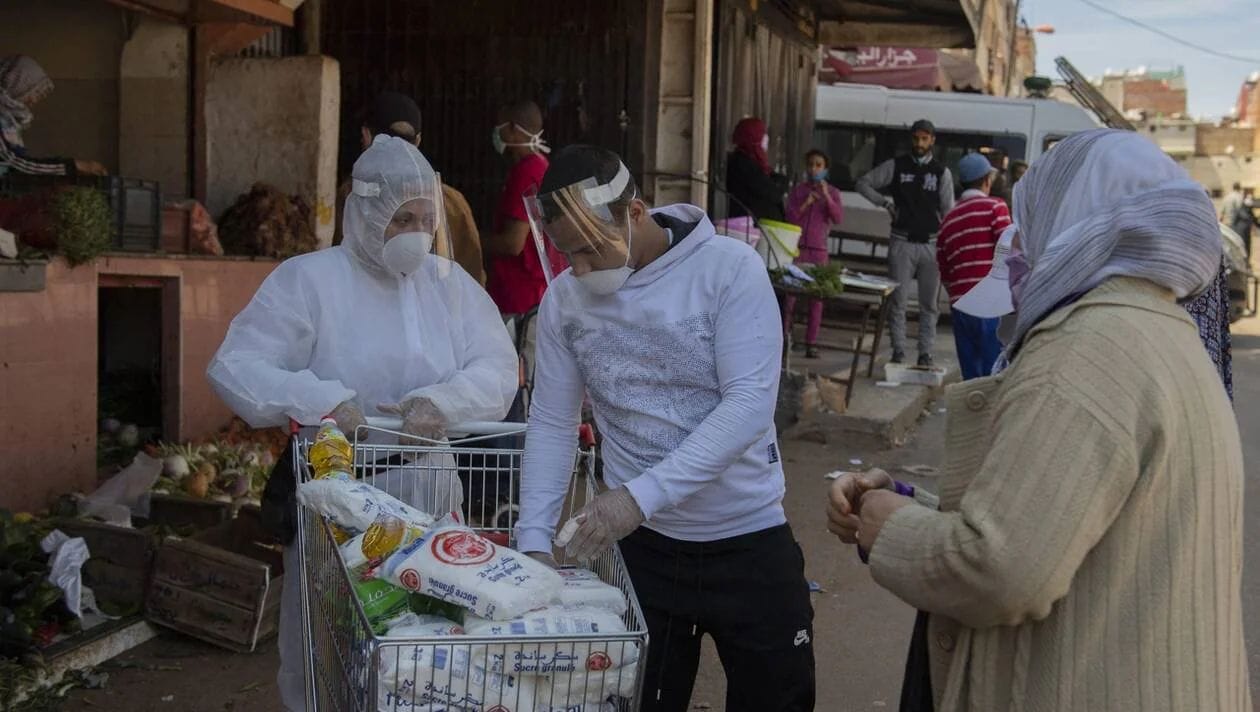 Distribution de nourriture aux plus démunis, à la sortie d’un supermarché de Rabat © EPA-EFE/JALAL MORCHIDI