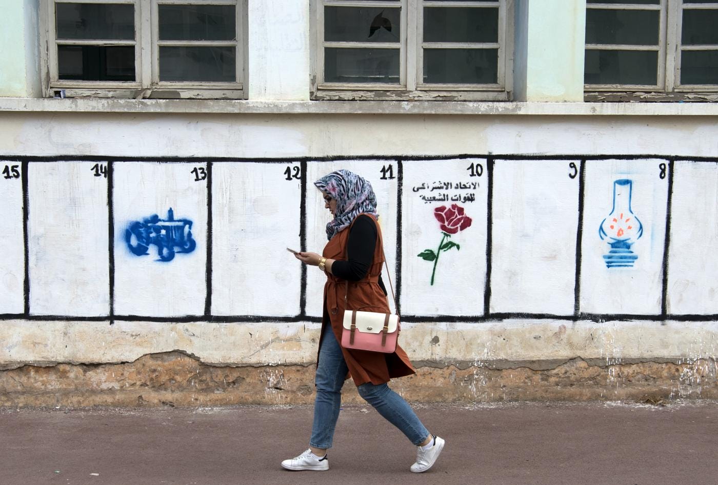 Une Marocaine passe devant des emplacements où sont peints les symboles des partis politiques du Royaume, le 4 septembre 2015 © AFP/Archives