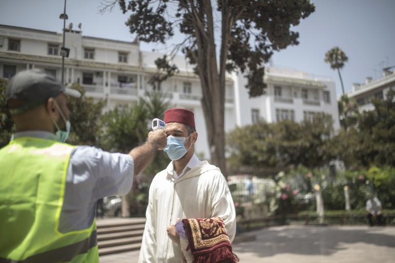 Dans les rues de Rabat, un employé effectue une prise de température d'un fidèle venu prier dans la grande mosquée de la ville, le 15 juillet 2020 © AP Photo/Mosa'ab Elshamy