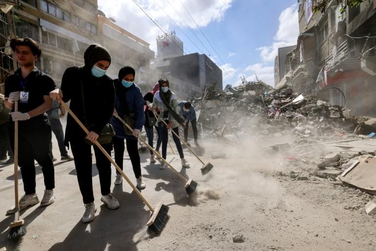 Après le cessez-le-feu, Gaza mesure les dégâts 2 Des volontaires palestiniens aident à retirer les gravats et à nettoyer une rue de Gaza, le 23 mai 2021 © AFP