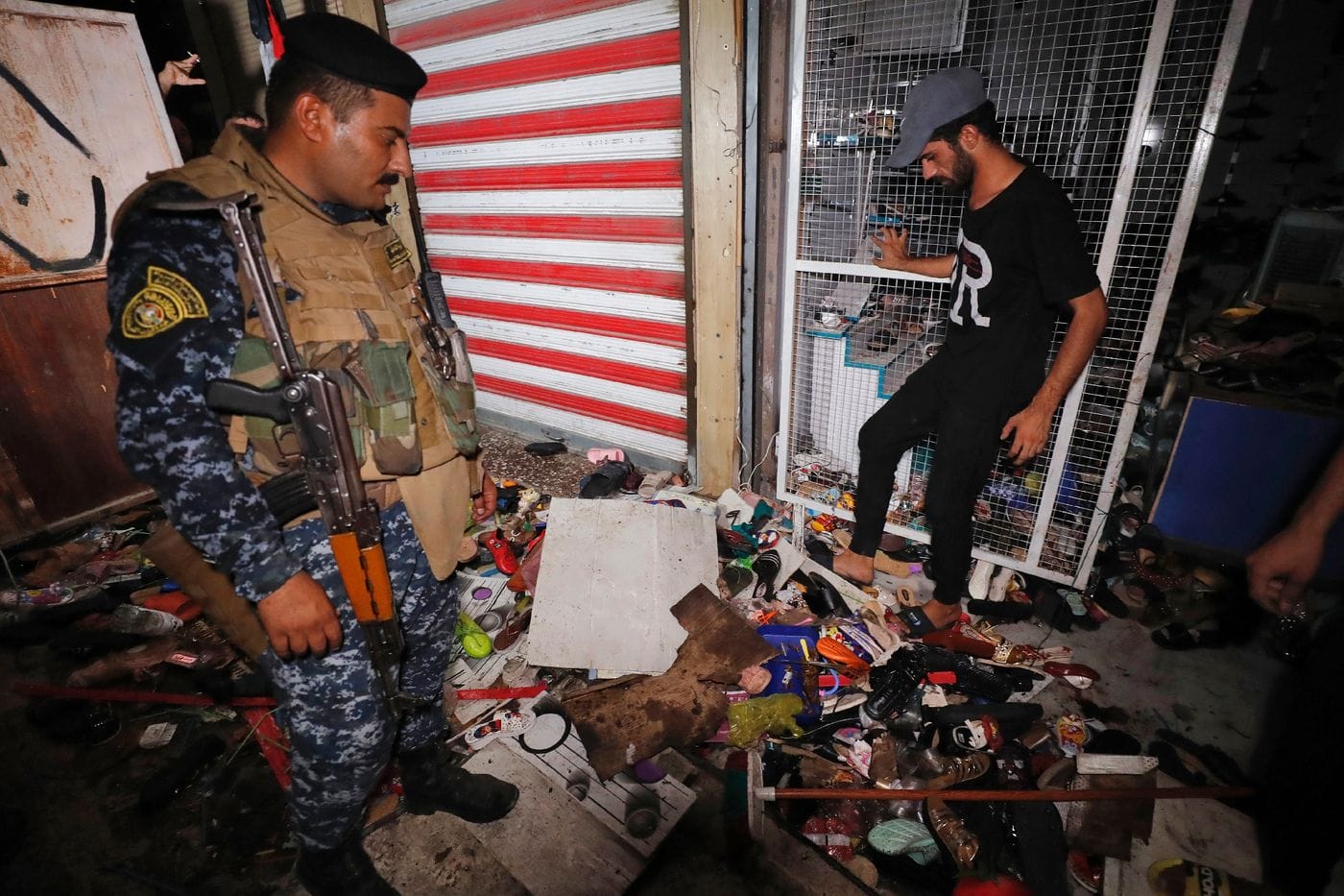 Des Irakiens inspectent les dégâts dans un marché de Bagdad après un attentat meurtrier, le 19 juillet 2021 © AFP