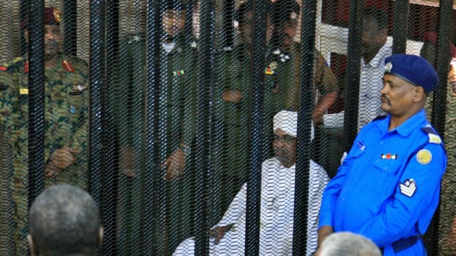 Le dirigeant militaire déchu du Soudan, Omar El-Béchir, est assis dans la cage des accusés à l'ouverture de son procès pour corruption à Khartoum, le 19 août 2019. PHOTO : GETTY IMAGES / EBRAHIM HAMID