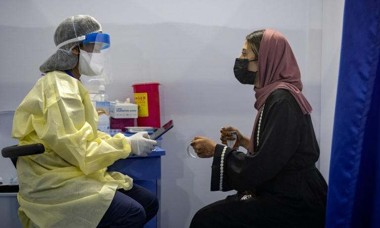 Covid-19 : frappé par la troisième vague, le Maroc mise tout sur la vaccination 2 Une infirmière scanne un code avant d'administrer un vaccin contre la Covid-19 à une femme le 9 août 2021 à Errahma, près de Casablanca © AFP
