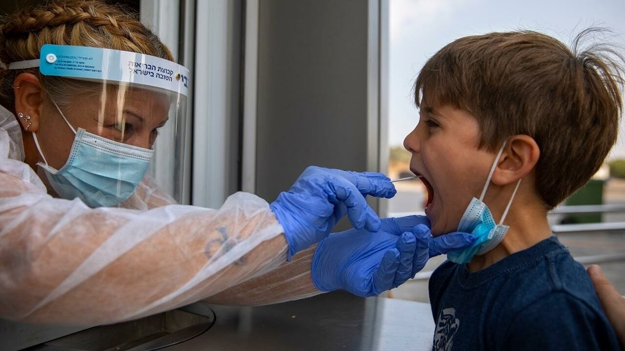 Une professionnelle de santé pratiquant un dépistage du Covid-19 sur un enfant à Tel Aviv, en Israël, le 9 août 2021. © AP - Oded Balilty, AP