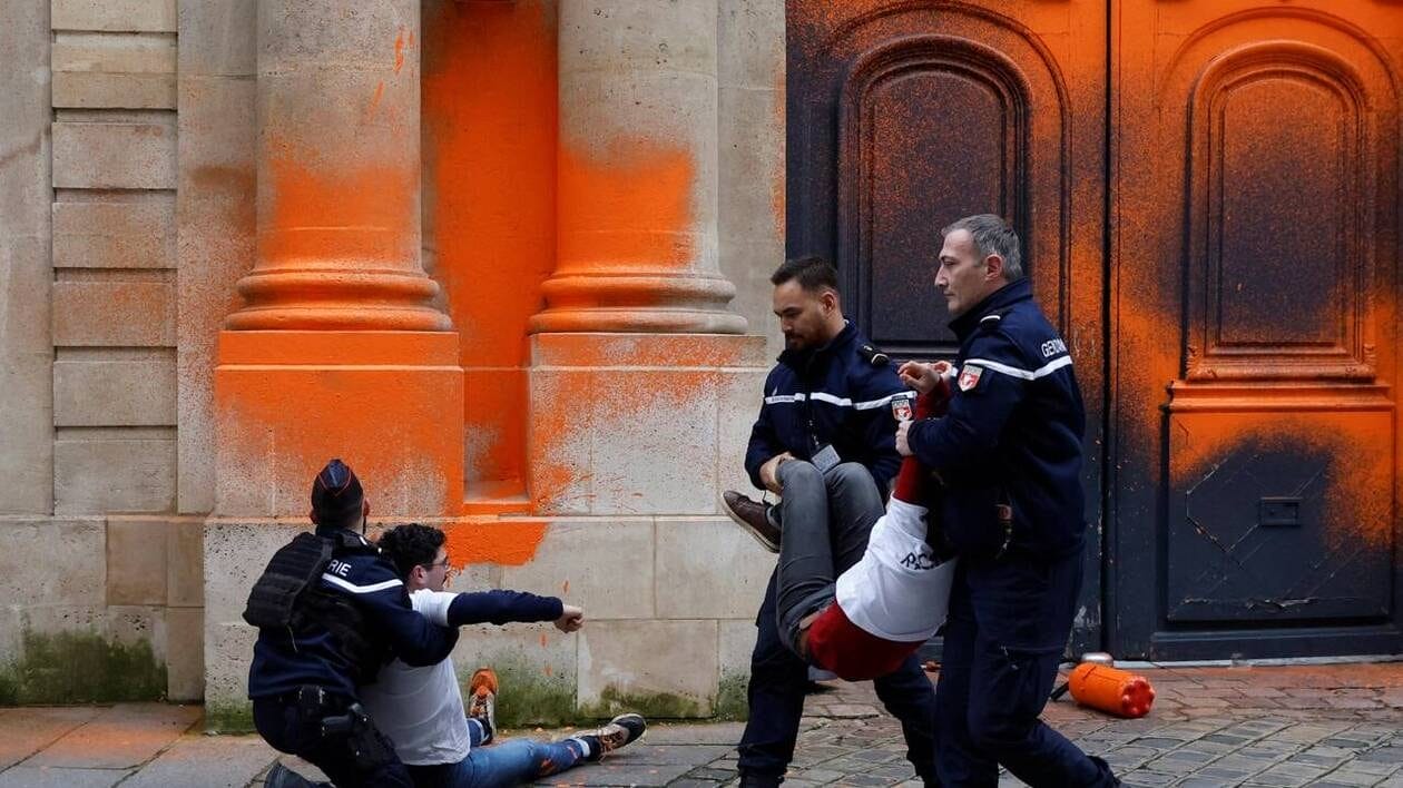 Des gendarmes arrêtent des militants écologistes du groupe Dernière rénovation qui ont pulvérisé de la peinture orange sur la façade de l’Hôtel Matignon, le 4 janvier 2023.