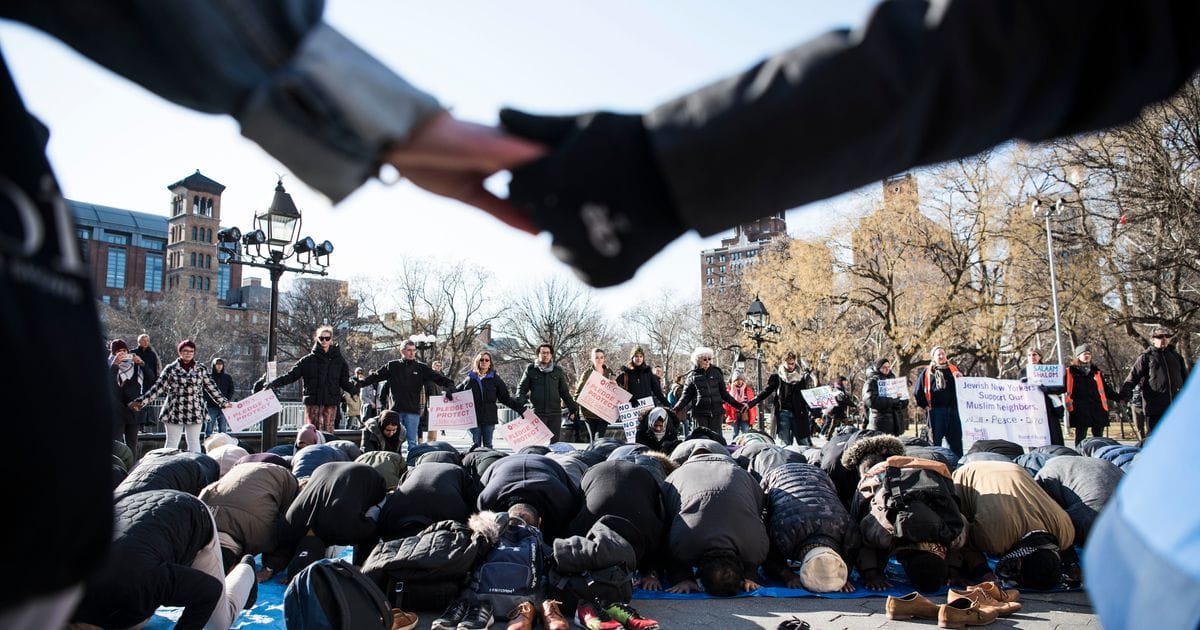 Des alliés interconfessionnels forment un cercle autour des musulmans priant dans le Washington Square Park de New York le 26 janvier 2018.