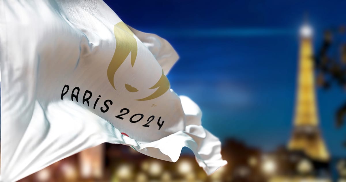 Le drapeau olympique flottant avec la tour eiffel en arrière plan